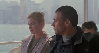 Movie still from “Double Impact” (1991), directed by Sheldon Lettich – A man and a woman sitting next to each other; Close Up shot, Low angle