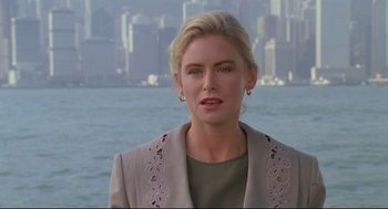 Movie still from “Double Impact” (1991), directed by Sheldon Lettich – A woman with blonde hair wearing a green shirt and a jacket; Close Up shot, Over the shoulder angle