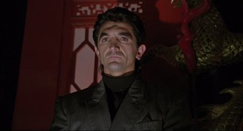 Movie still from “Double Impact” (1991), directed by Sheldon Lettich – A man in a black jacket and a black shirt; Close Up shot, Low angle