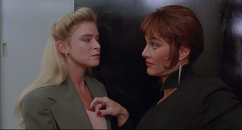 Movie still from “Double Impact” (1991), directed by Sheldon Lettich – Two women are standing next to each other; Close Up shot, Over the shoulder angle