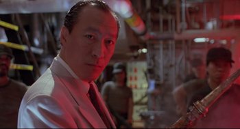 Movie still from “Double Impact” (1991), directed by Sheldon Lettich – A person wearing a suit and a tie; Close Up shot, Low angle