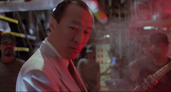 Movie still from “Double Impact” (1991), directed by Sheldon Lettich – A person wearing a suit and tie; Close Up shot, Low angle