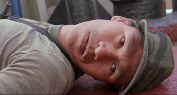 Movie still from “Double Impact” (1991), directed by Sheldon Lettich – A person laying on the ground; Close Up shot, Overhead angle