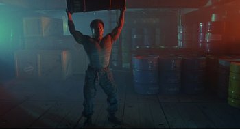 Movie still from “Double Impact” (1991), directed by Sheldon Lettich – A man holding a barrel in a room with smoke; Wide shot, Low angle