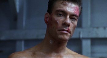 Movie still from “Double Impact” (1991), directed by Sheldon Lettich – A person with blood on his face; Close Up shot, Low angle