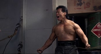 Movie still from “Double Impact” (1991), directed by Sheldon Lettich – A man with his mouth wide open and his hands in the air; Medium shot, Low angle