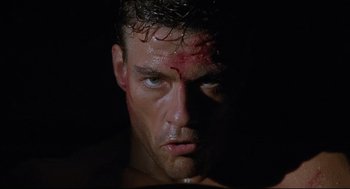 Movie still from “Double Impact” (1991), directed by Sheldon Lettich – A person with blood all over his face; Close Up shot, Low angle