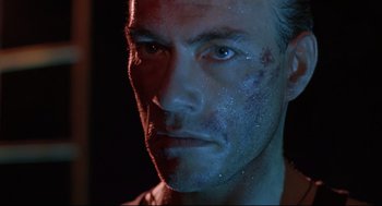 Movie still from “Double Impact” (1991), directed by Sheldon Lettich – A person with a face covered in dirt; Close Up shot, Low angle