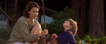 Movie still from “Double Jeopardy” (1999), directed by Bruce Beresford – A woman and a boy holding a fishing pole; Medium shot, Low angle