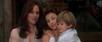 Movie still from “Double Jeopardy” (1999), directed by Bruce Beresford – Two women and a boy pose for a picture; Close Up shot, Over the shoulder angle
