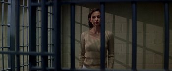 Movie still from “Double Jeopardy” (1999), directed by Bruce Beresford – A woman standing behind bars in a jail cell; Medium shot, Low angle