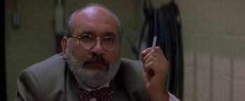 Movie still from “Double Jeopardy” (1999), directed by Bruce Beresford – An older man in a suit and bow tie holding a cigarette in his hand; Close Up shot, Low angle