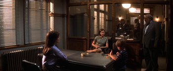 Movie still from “Double Jeopardy” (1999), directed by Bruce Beresford – A group of people sitting around a table; Wide shot, Over the shoulder angle