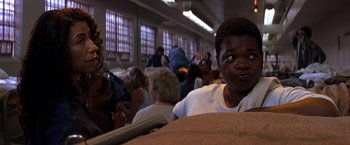 Movie still from “Double Jeopardy” (1999), directed by Bruce Beresford – A man sitting in a room full of people; Close Up shot, High angle