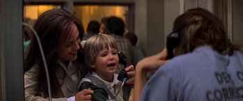 Movie still from “Double Jeopardy” (1999), directed by Bruce Beresford – A young boy is being held up by a woman; Close Up shot, Over the shoulder angle