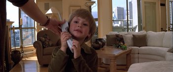 Movie still from “Double Jeopardy” (1999), directed by Bruce Beresford – A young boy is playing a video game with a remote controller; Close Up shot, High angle