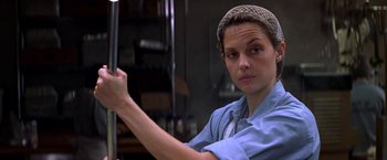 Movie still from “Double Jeopardy” (1999), directed by Bruce Beresford – A woman in a blue shirt holding a metal pole; Close Up shot, Low angle