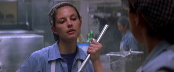 Movie still from “Double Jeopardy” (1999), directed by Bruce Beresford – A woman holding a metal pole in a room; Close Up shot, Low angle