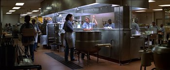 Movie still from “Double Jeopardy” (1999), directed by Bruce Beresford – A woman standing next to a large pot in a kitchen; Wide shot, High angle