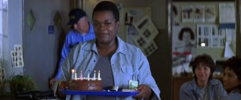 Movie still from “Double Jeopardy” (1999), directed by Bruce Beresford – A woman holding a tray with a birthday cake on it; Medium shot, High angle
