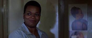 Movie still from “Double Jeopardy” (1999), directed by Bruce Beresford – A woman smiling for the camera in front of a wall; Close Up shot, Low angle