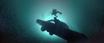 Movie still from “Double Jeopardy” (1999), directed by Bruce Beresford – A scuba diver is swimming in the water; Wide shot, Overhead angle