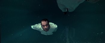 Movie still from “Double Jeopardy” (1999), directed by Bruce Beresford – A man swimming in a body of water; Medium shot, Overhead angle