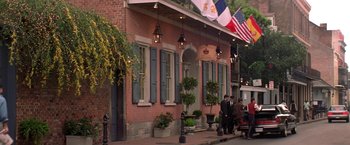 Movie still from “Double Jeopardy” (1999), directed by Bruce Beresford – A group of people standing on the sidewalk outside of a building; Extreme Wide shot, Low angle