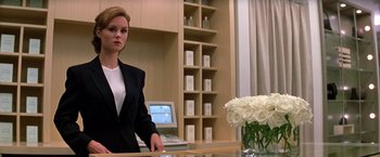 Movie still from “Double Jeopardy” (1999), directed by Bruce Beresford – A woman standing at a desk in front of a computer; Medium shot, Low angle