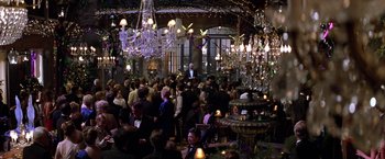 Movie still from “Double Jeopardy” (1999), directed by Bruce Beresford – A group of people standing in a room with chandeliers; Extreme Wide shot, High angle