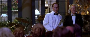 Movie still from “Double Jeopardy” (1999), directed by Bruce Beresford – A man wearing a white suit and bow tie; Medium shot, Over the shoulder angle