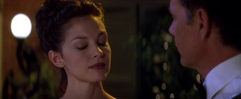 Movie still from “Double Jeopardy” (1999), directed by Bruce Beresford – A beautiful young woman with eyes closed and a hand on her chin; Close Up shot, Over the shoulder angle