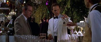 Movie still from “Double Jeopardy” (1999), directed by Bruce Beresford – A man in a white suit and a black bow tie; Medium shot, Over the shoulder angle