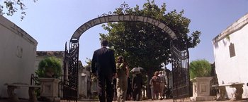 Movie still from “Double Jeopardy” (1999), directed by Bruce Beresford – A group of people walking under a metal arch; Extreme Wide shot, Low angle