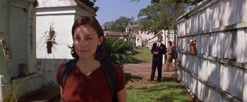 Movie still from “Double Jeopardy” (1999), directed by Bruce Beresford – A woman standing in the grass near a group of people; Medium shot, Over the shoulder angle