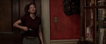 Movie still from “Double Jeopardy” (1999), directed by Bruce Beresford – A woman standing in a doorway holding a gun; Medium shot, Low angle