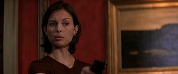 Movie still from “Double Jeopardy” (1999), directed by Bruce Beresford – A woman is holding a gun in a room; Close Up shot, Over the shoulder angle