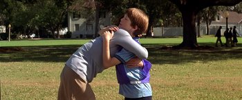 Movie still from “Double Jeopardy” (1999), directed by Bruce Beresford – Two young boys hugging each other in a park; Medium shot, Over the shoulder angle