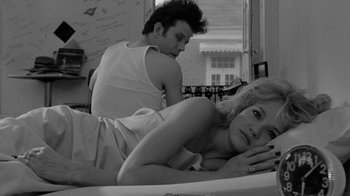Movie still from “Down by Law” (1986), directed by Jim Jarmusch – A man and a woman laying on a bed in a room; Medium shot, Low angle