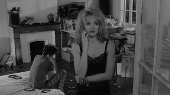 Movie still from “Down by Law” (1986), directed by Jim Jarmusch – A woman in a black top is on the phone; Medium shot, Over the shoulder angle