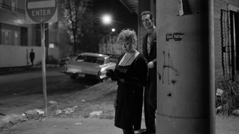 Movie still from “Down by Law” (1986), directed by Jim Jarmusch – A man and a woman standing next to each other on the street; Medium shot, Over the shoulder angle