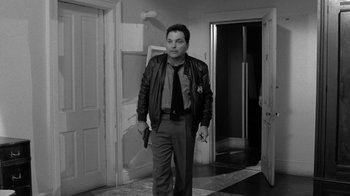 Movie still from “Down by Law” (1986), directed by Jim Jarmusch – A black and white photo of a man holding a gun; Medium shot, Low angle