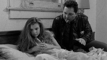 Movie still from “Down by Law” (1986), directed by Jim Jarmusch – A man and a woman sitting next to each other in a bed; Medium shot, Over the shoulder angle