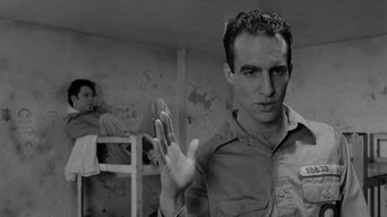 Movie still from “Down by Law” (1986), directed by Jim Jarmusch – A black - and - white photo of a man holding his hand up; Close Up shot, Low angle