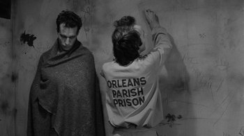 Movie still from “Down by Law” (1986), directed by Jim Jarmusch – A group of people standing next to each other in front of a wall; Medium shot, Over the shoulder angle