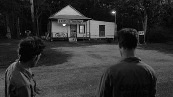 Movie still from “Down by Law” (1986), directed by Jim Jarmusch – Two men standing in front of an old building; Wide shot, Over the shoulder angle