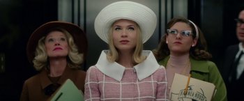 Movie still from “Down with Love” (2003), directed by Peyton Reed – A woman wearing a white hat and a pink coat; Close Up shot, Low angle