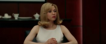 Movie still from “Down with Love” (2003), directed by Peyton Reed – A woman in a white dress sitting in front of a table; Close Up shot, Over the shoulder angle