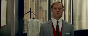 Movie still from “Down with Love” (2003), directed by Peyton Reed – A man standing in front of a suit and tie; Medium shot, Over the shoulder angle