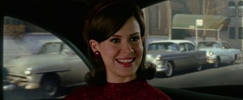 Movie still from “Down with Love” (2003), directed by Peyton Reed – A woman in a red dress sitting in the back of a car; Close Up shot, Over the shoulder angle